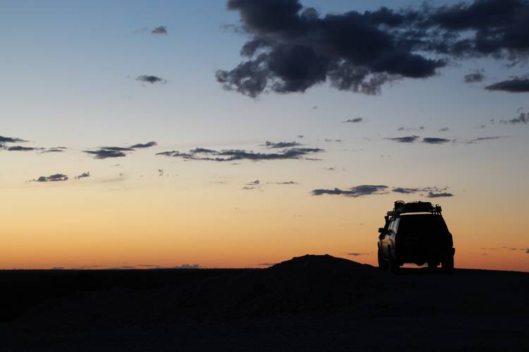 four wheel drive cars silhouetted at sunset
